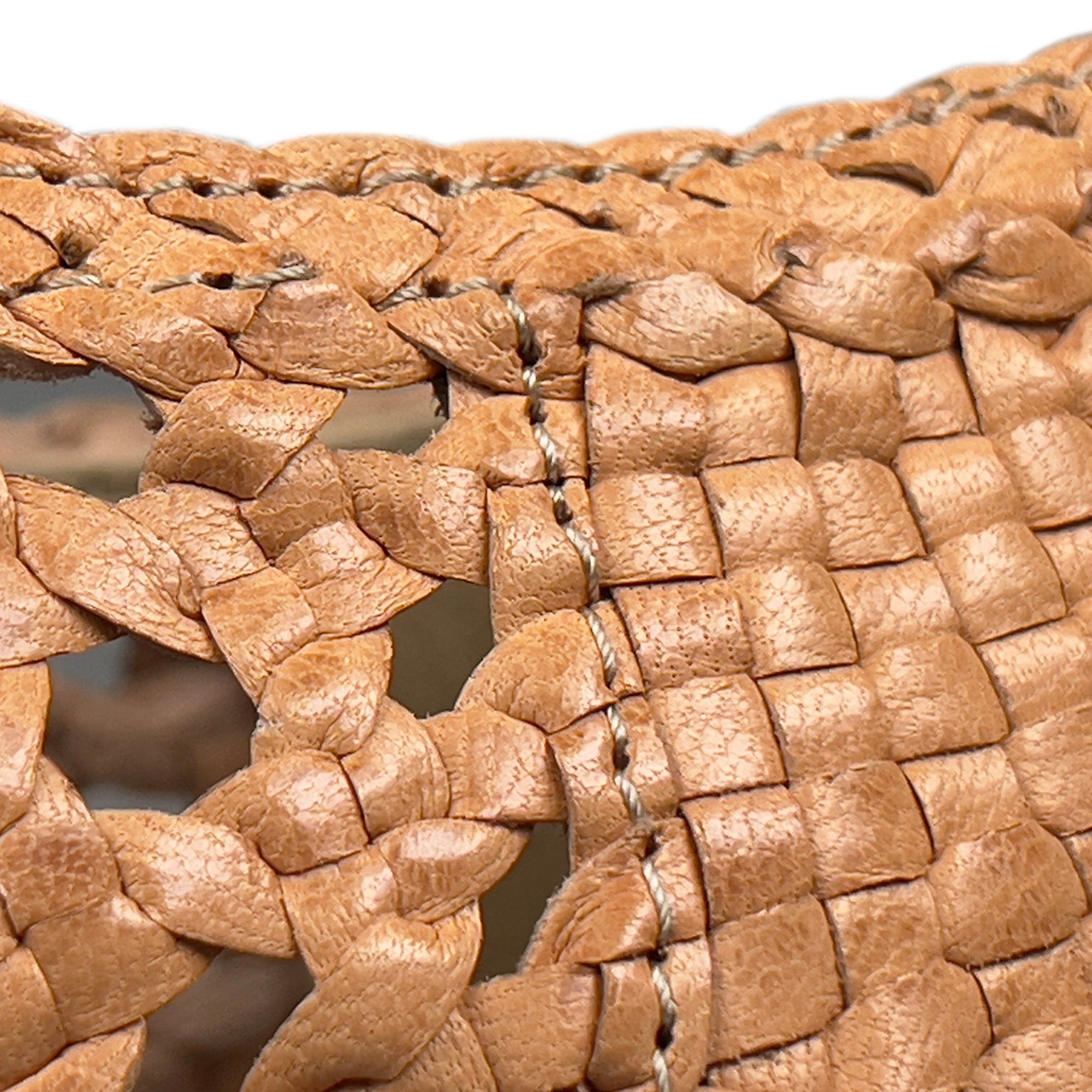 Nahaufnahme des geflochtenen Schuhmaterials. Beige, geflochtenes Leder. Sichtbare Nähte.