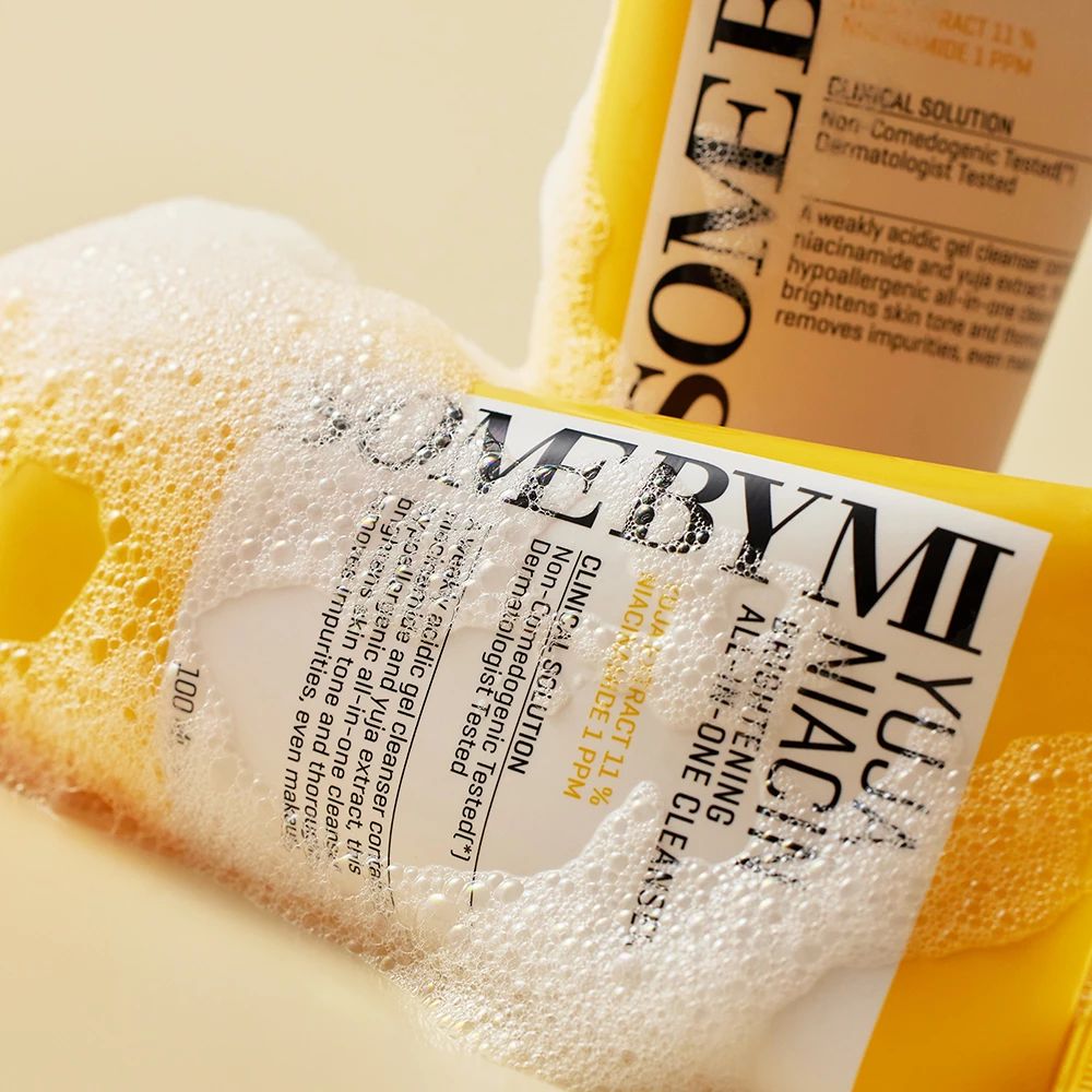 Gelbe Tube mit Aufschrift Yuja Niacin Brightening All-in-One Cleanser. Marke: SOME BY MI. Liegt in Seifenschaum.