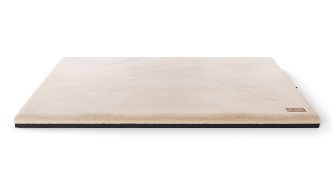 Orthopädische Hundematte, rechteckig, beige, mit schwarzem Rand. Kleines Label an der Seite.
