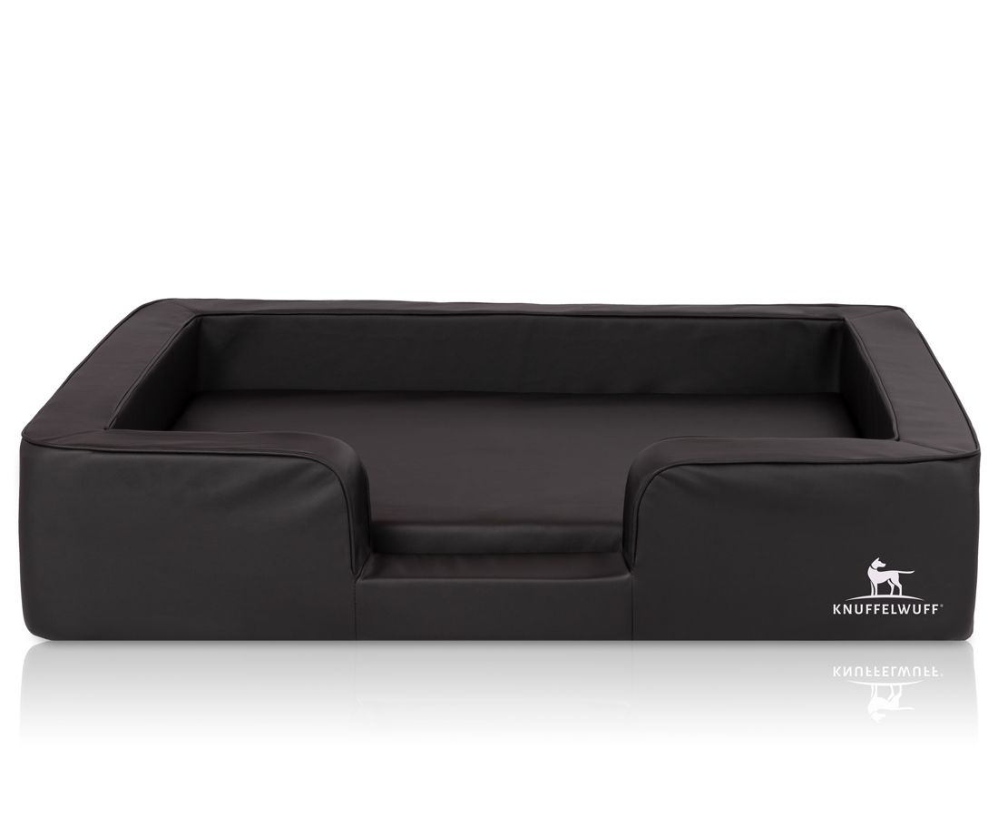 Schwarzes orthopädisches Hundebett mit erhöhtem Rand und beigem Liegebereich. Logo: Knuffelwuff.