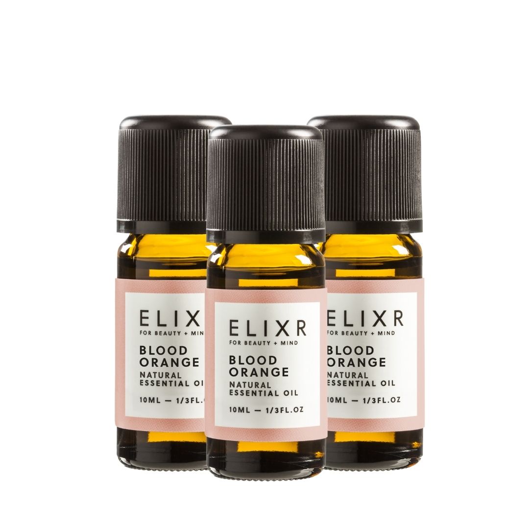 Drei kleine Glasflaschen mit schwarzem Deckel und Etikett. Aufschrift: ELIXR, Blood Orange, Natural Essential Oil.