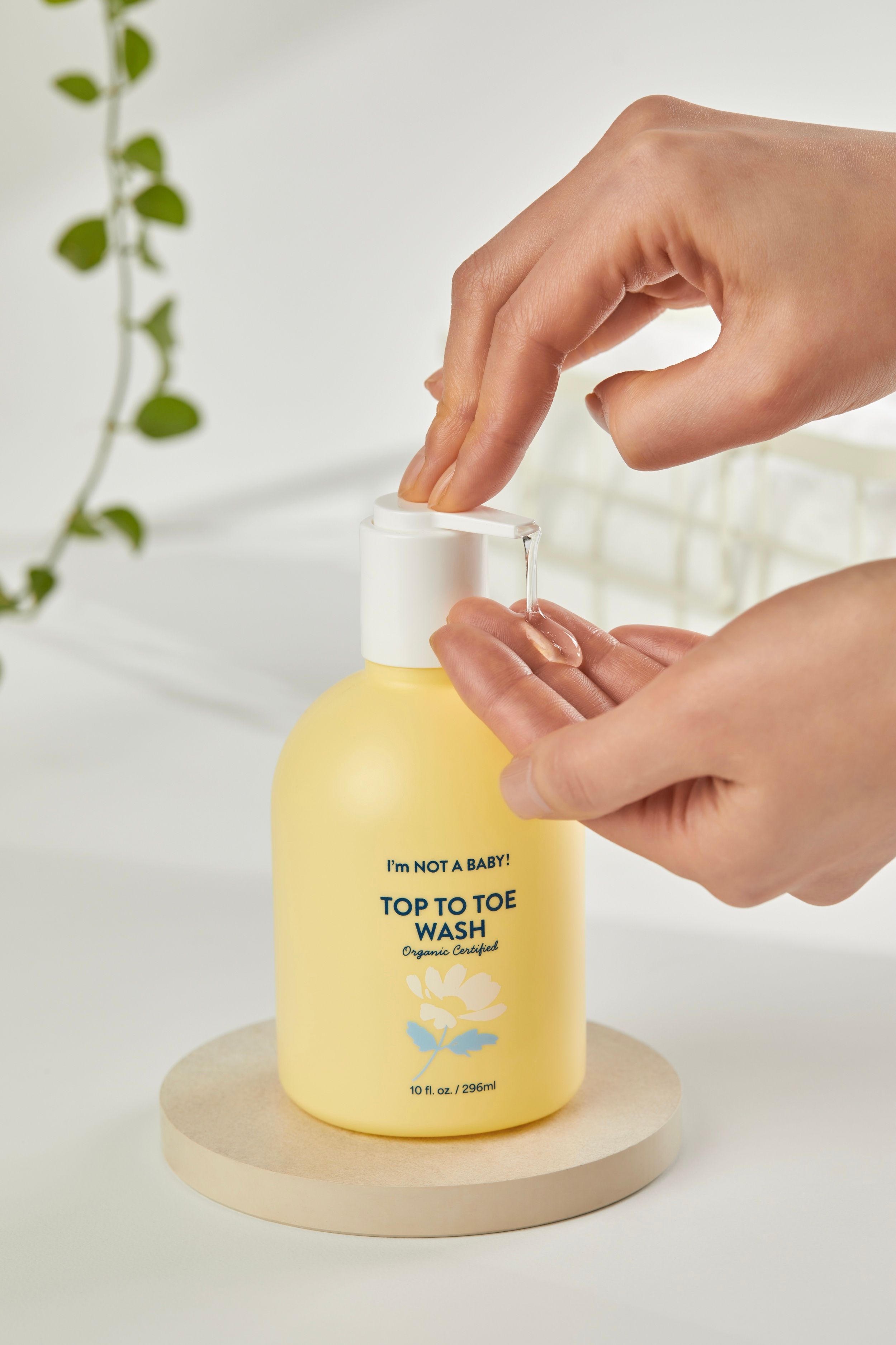 Gelbe Pumpflasche mit "TOP TO TOE WASH" Aufschrift und einer Hand, die Flüssigkeit entnimmt.