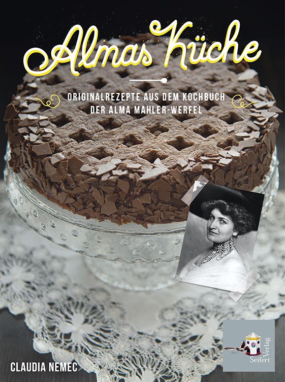 Buchcover mit Kuchen. Titel: Almas Küche. Autorin: Claudia Nemec. Verlag: Seifert Verlag. Foto einer Frau. Kuchen auf Glasplatte.