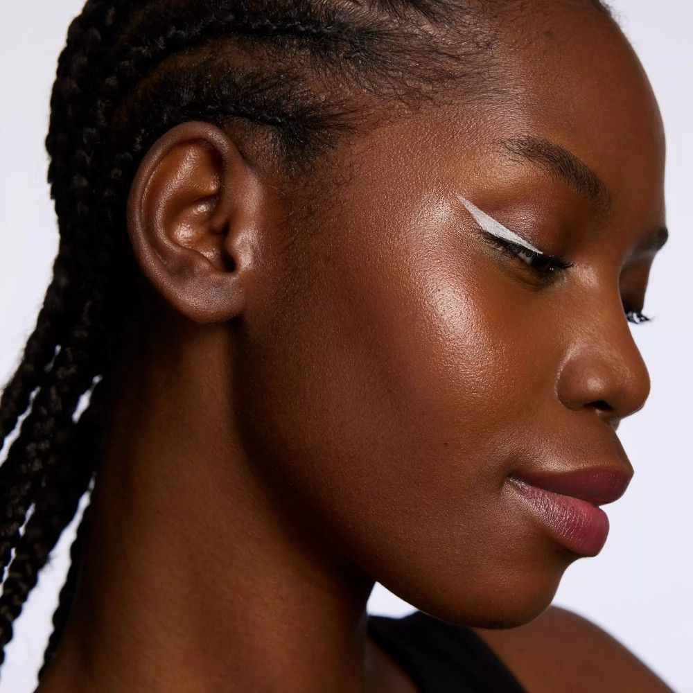 Porträt einer Frau mit weißem Eyeliner. Sichtbare Augen, Lippen und Haut.