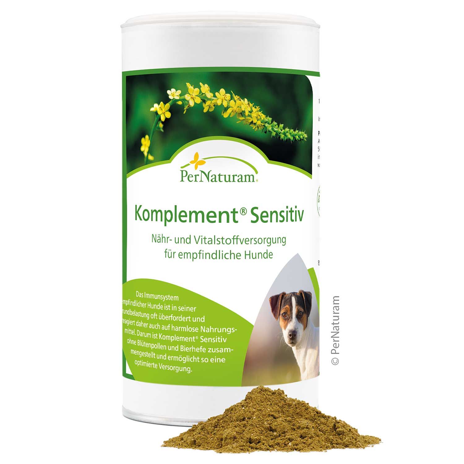 Zylindrische Dose mit "PerNaturam Komplement Sensitiv". Braunes Pulver davor. Hundefoto.