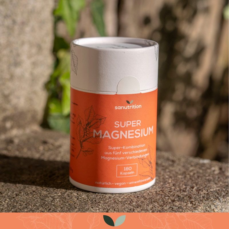 Zylindrische Dose mit orangefarbener Etikettierung. Aufschrift: Super Magnesium, 180 Kapseln. Steht auf Stein.