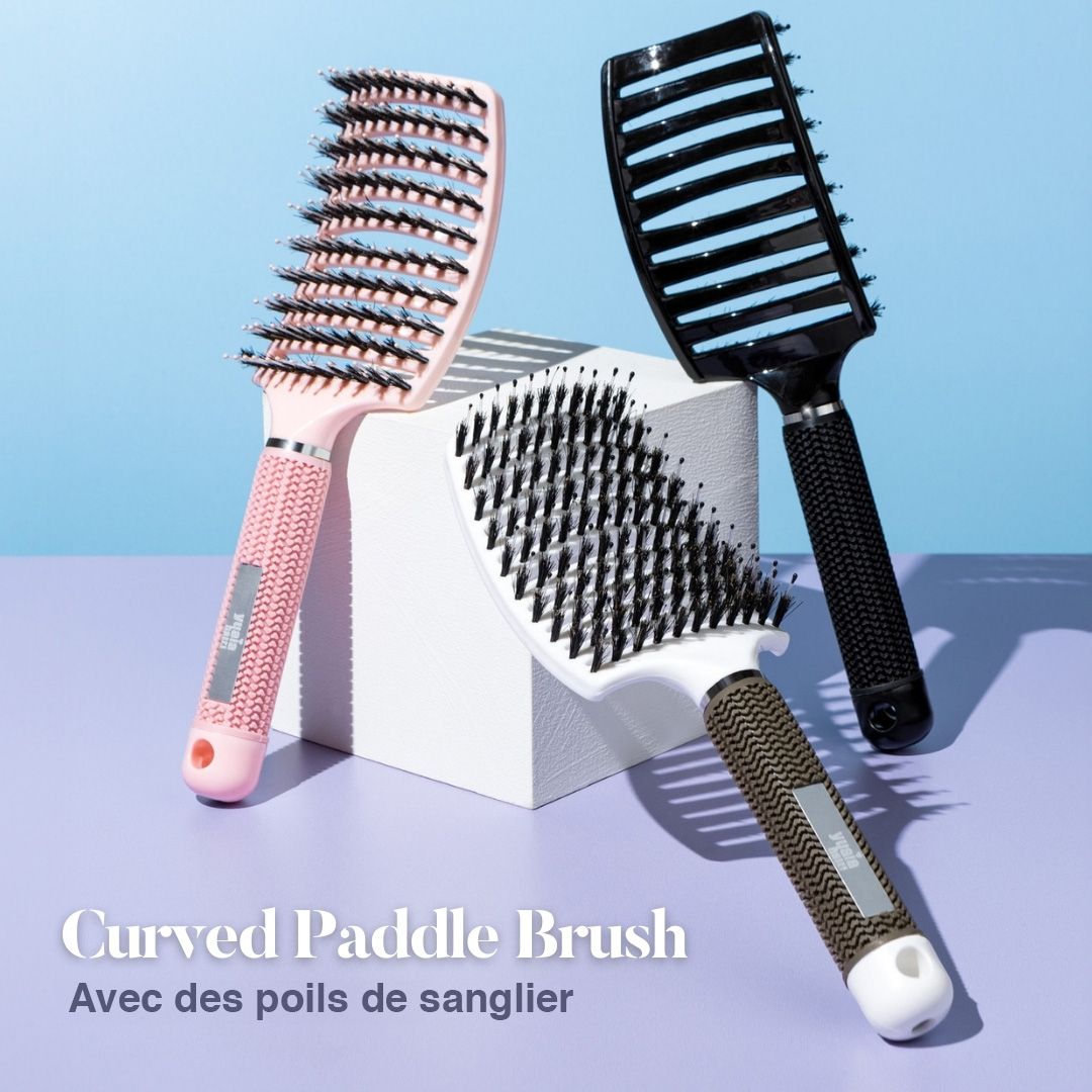 Trois brosses à palette incurvées en rose, noir et blanc. Inscription : Curved Paddle Brush.