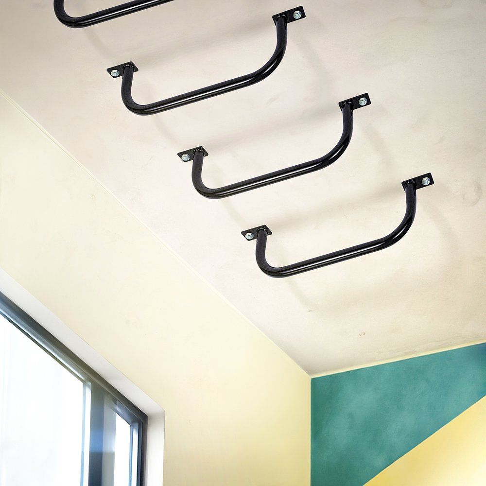 Mehrere schwarze Hangelgriffe an einer Decke montiert. Gebogene Form. Blickwinkel von unten.