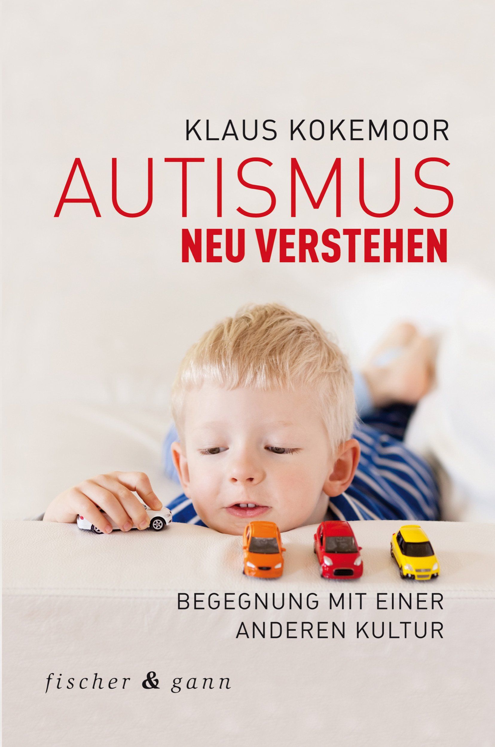 Buchcover: "Autismus neu verstehen" von Klaus Kokemoor. Kind mit Spielzeugautos. Verlag fischer & gann.