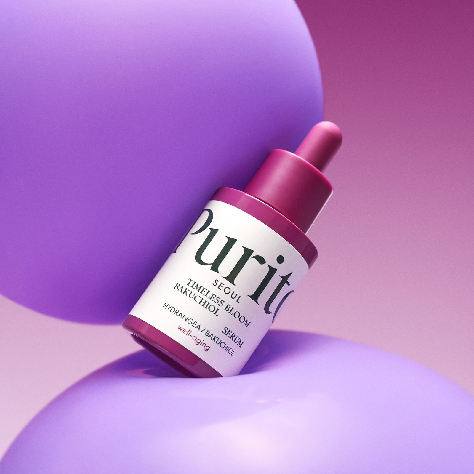 Flasche mit Pipette, Purito Bakuchiol Serum, auf lila Kugeln.