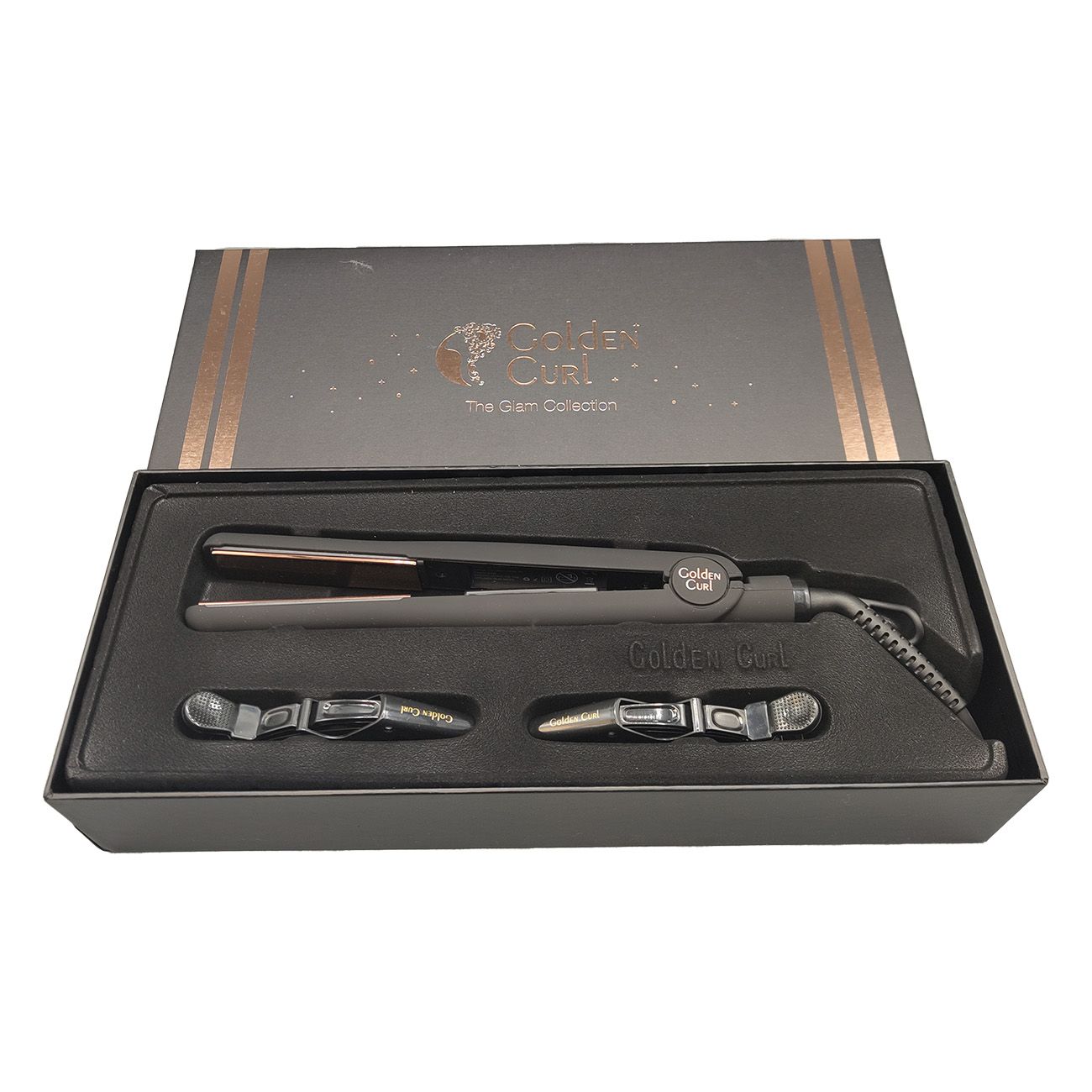 Geöffnete schwarze Box mit Glätteisen und Zubehör. Glätteisen mit goldfarbenen Platten. Zwei Haarspangen.