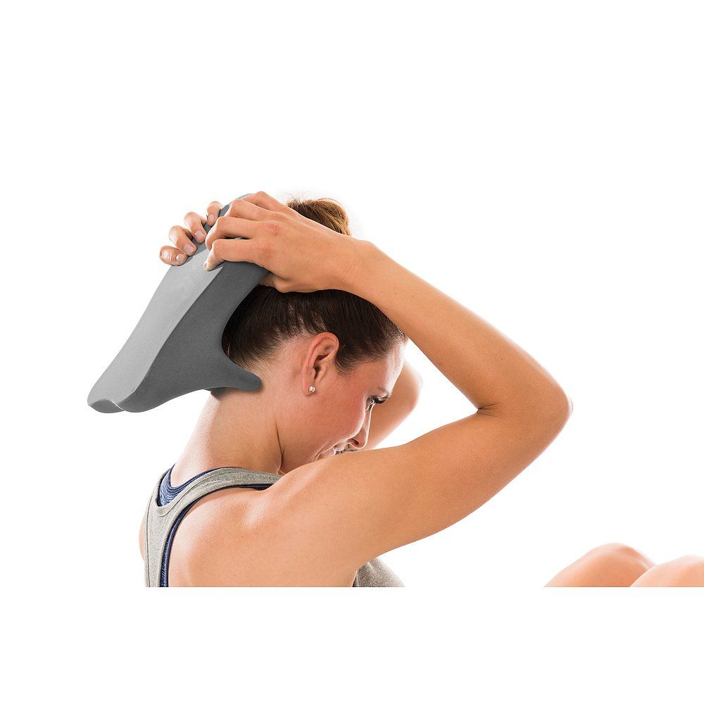 Graues Faszientool am Hinterkopf. Frau hält das Tool mit beiden Händen.