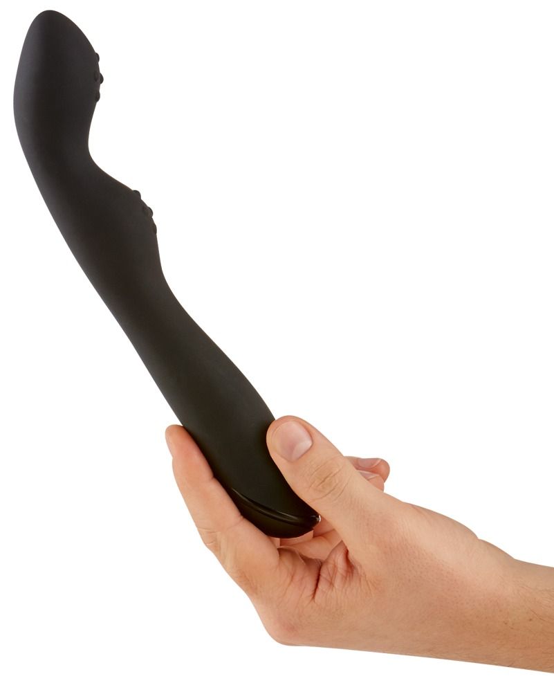 Schwarzer Vibrator, gehalten in einer Hand. Geschwungene Form mit erhabenen Noppen.