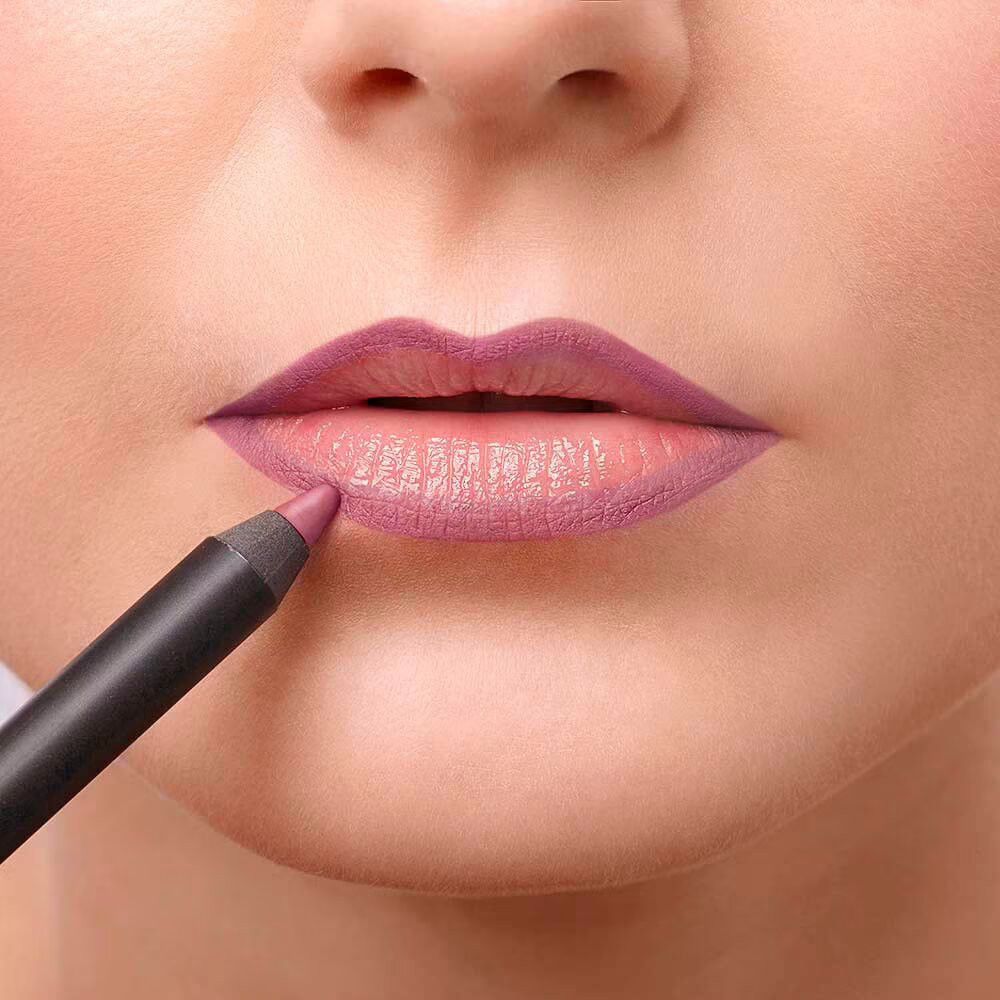 Lippenstift wird auf Lippen aufgetragen. Schwarzer Stift, rosa Mine. Haut im Hintergrund.