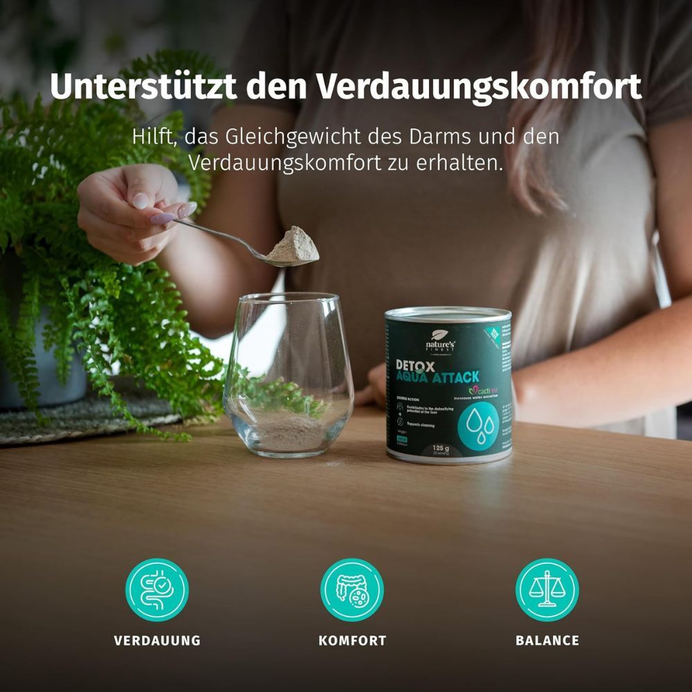 Pulver wird aus Löffel in Glas geschöpft, neben Dose Nature's Finest Detox Aqua Attack.