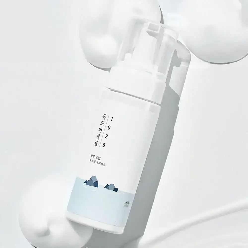 Weiße Flasche mit Aufschrift und Abbildung. Transparenter Pumpkopf. Produktname und Zahlen aufgedruckt.