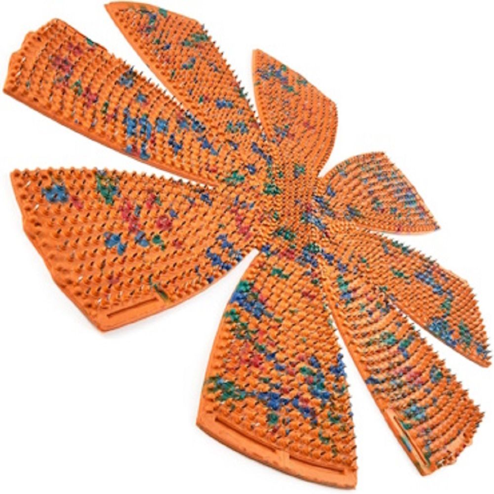 Orangefarbene Matte mit Noppen. Die Matte ist in Form einer Blume angeordnet.