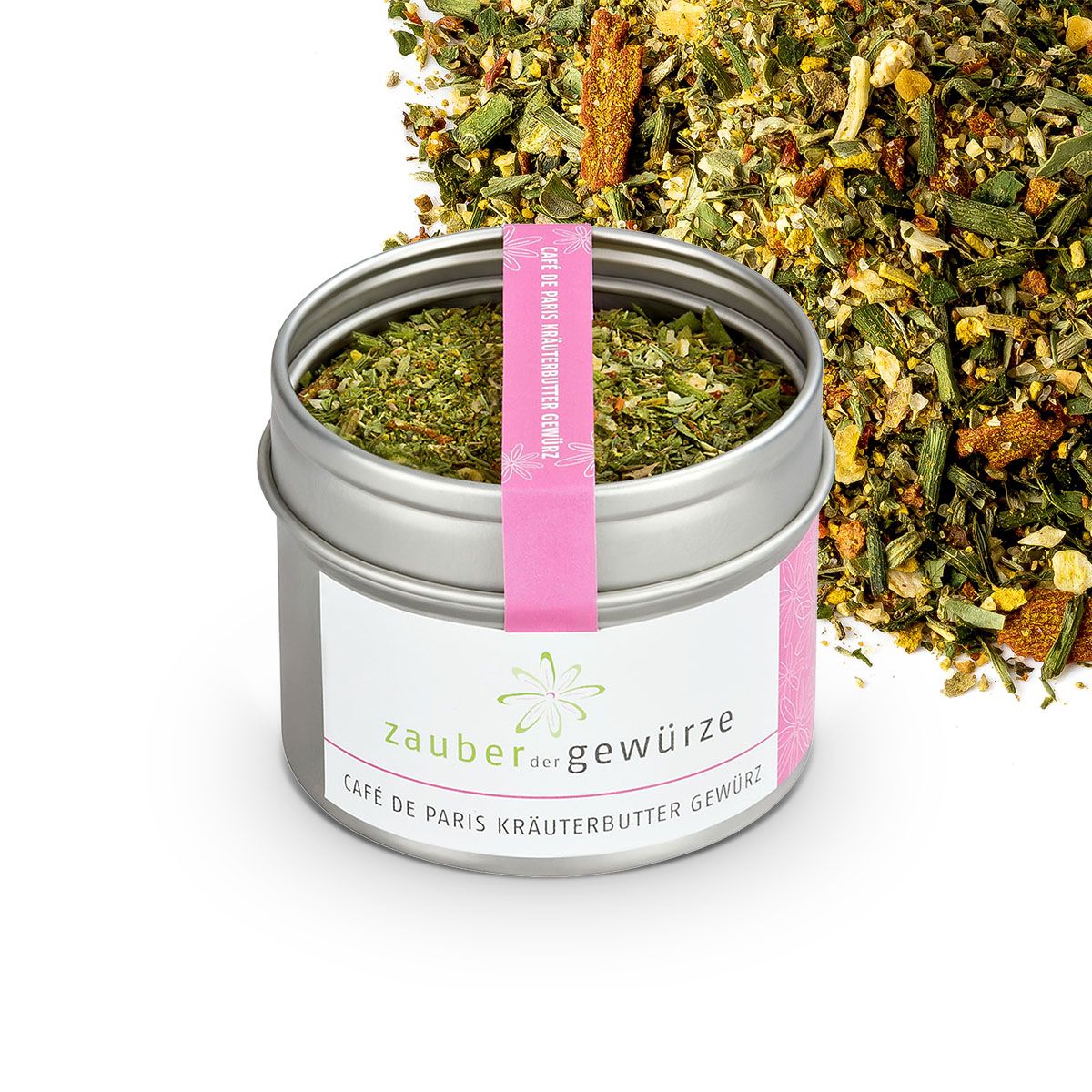 Offener Metallbehälter mit Kräutermischung. Rosa Band mit Text. Kräuter daneben. Aufschrift: Zauber der Gewürze Café de Paris Kräuterbutter Gewürz.