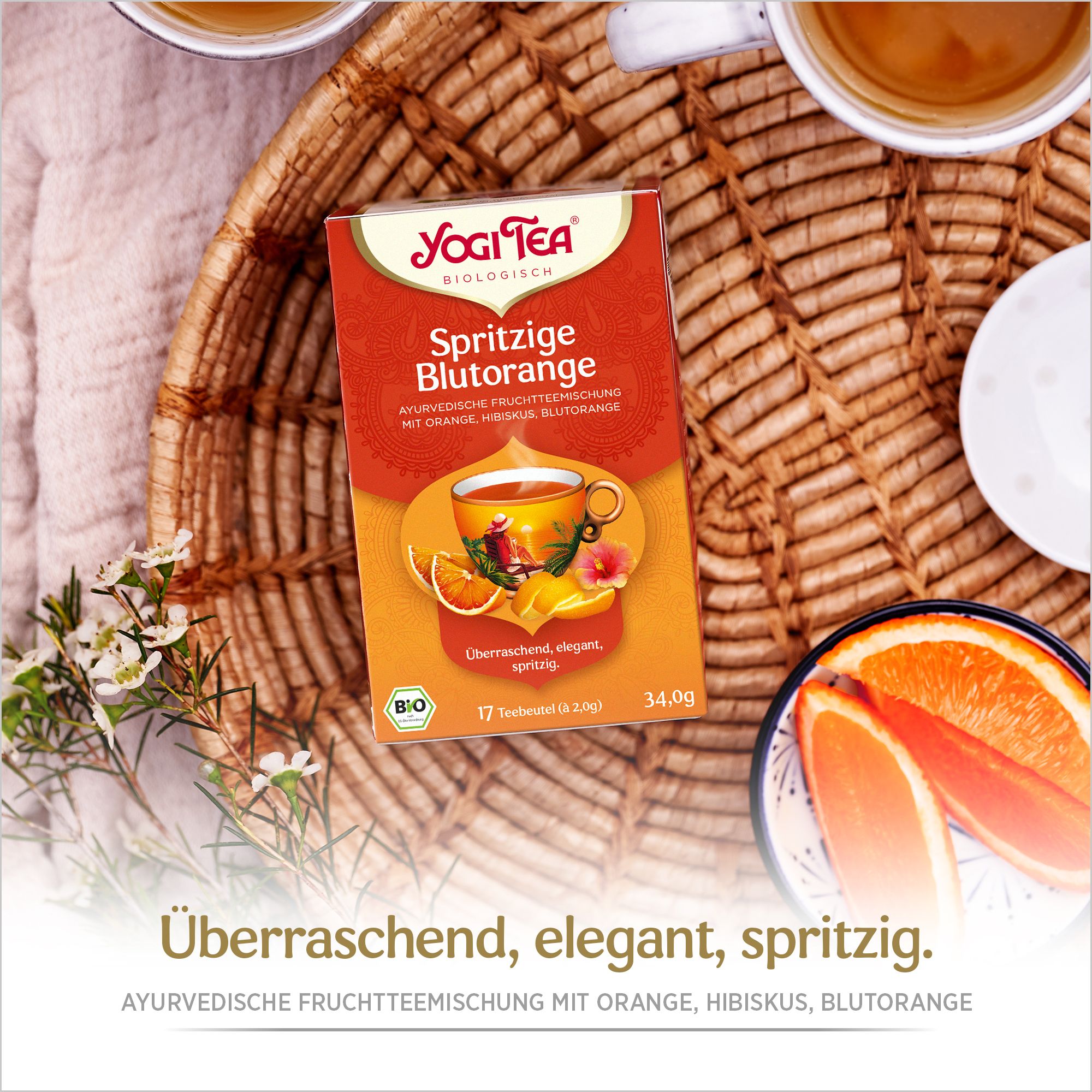 Yogi Tea-Verpackung auf einem Tablett. Orangefarbenes Design mit Produktnamen und Illustrationen. 17 Teebeutel. Bio-Siegel.
