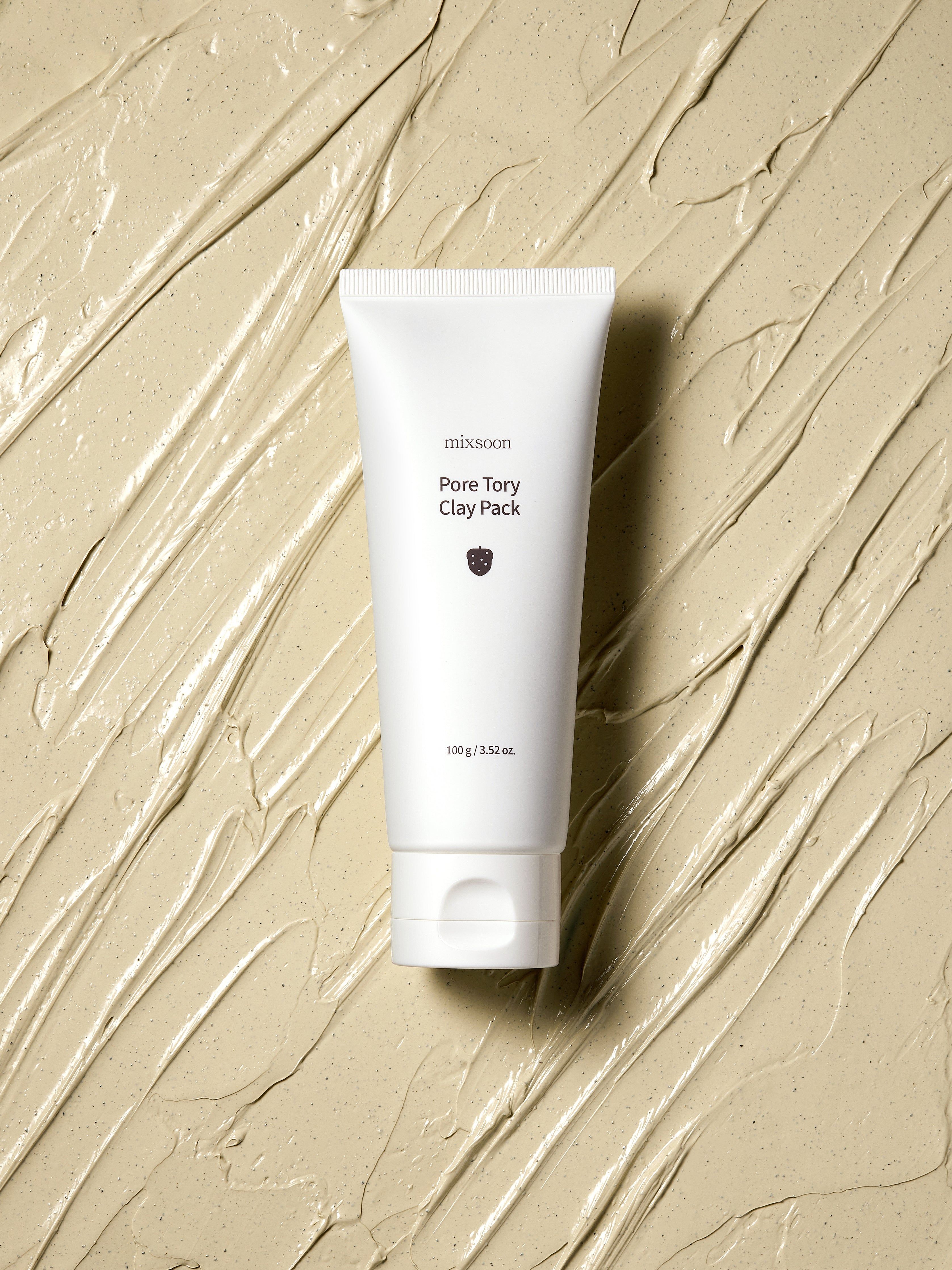 Weiße Tube auf beigem Untergrund. Produktname und Logo sichtbar. Text: Pore Tory Clay Pack, 100 g / 3.52 oz.