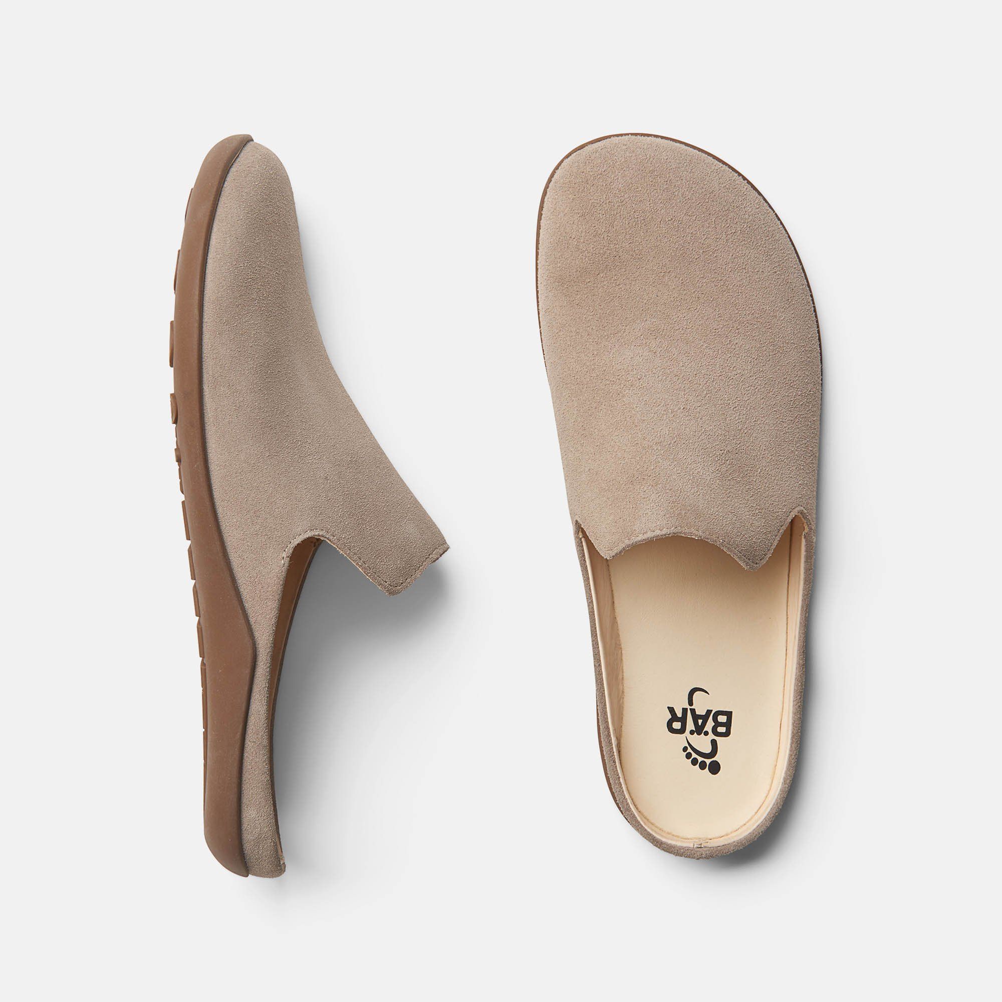 Pantolette von oben und von der Seite. Beige Wildleder, braune Sohle. Innensohle mit Logo.