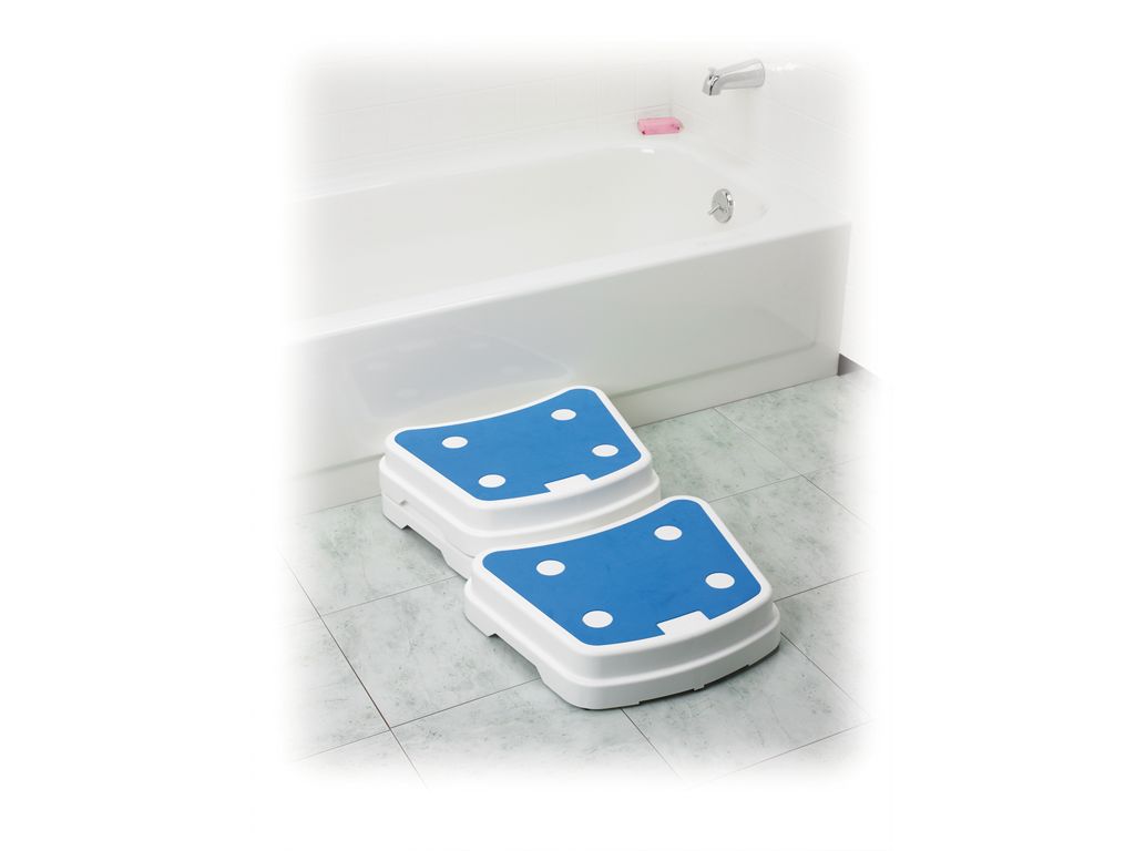 Zwei weiße Trittstufen mit blauen Oberflächen im Badezimmer, neben einer Badewanne.