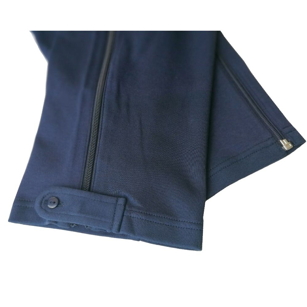 Detailansicht des blauen Overalls. Reißverschluss am Bein, Knopfverschluss am Knöchel. Stoff aus der Nähe.