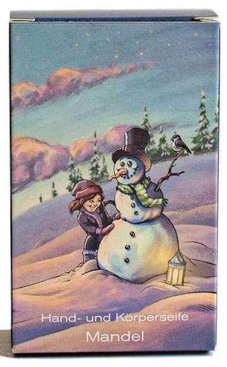 Verpackung mit Winterlandschaft, Schneemann und Kind. Text: Hand- und Körperseife Mandel.