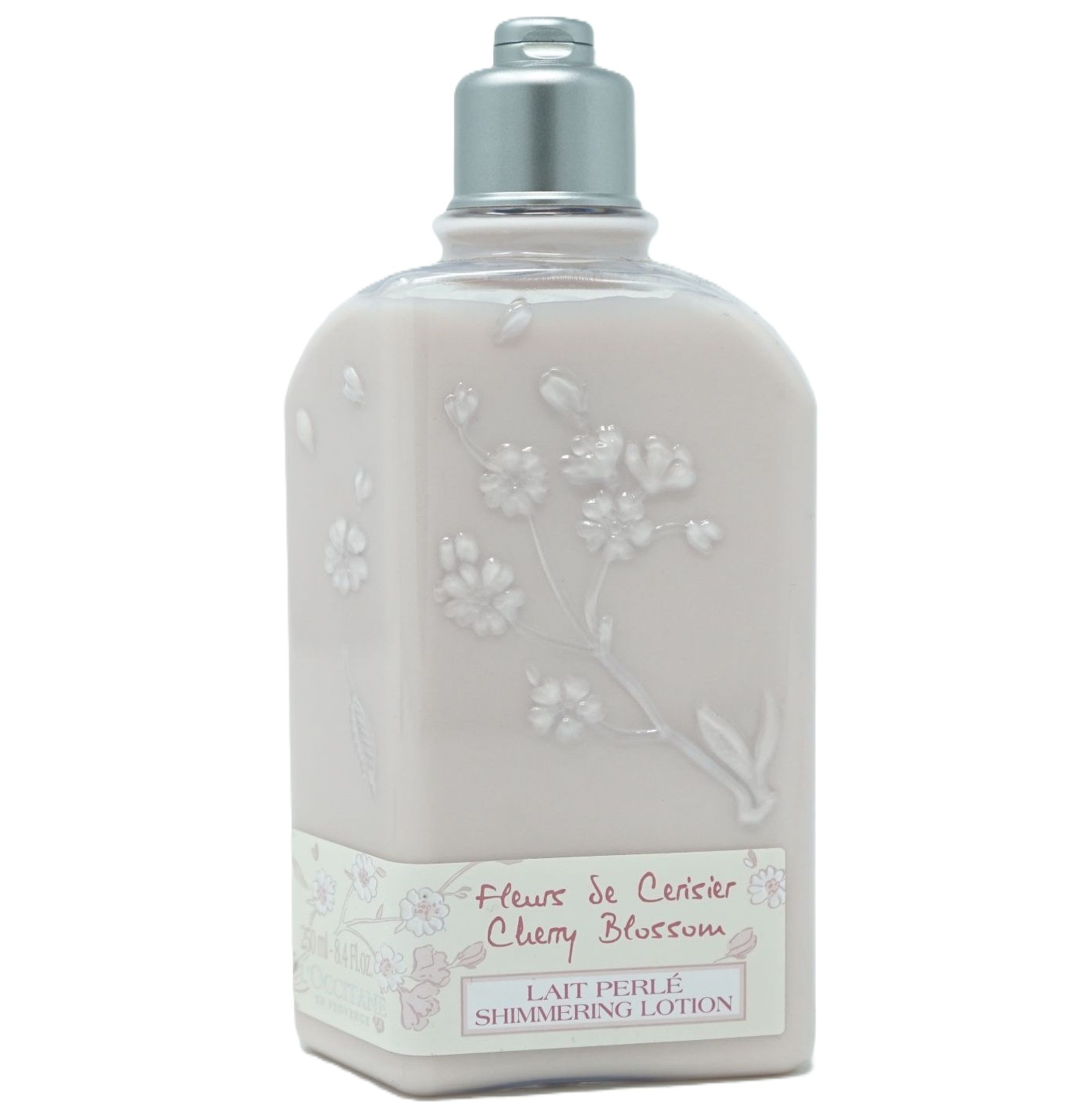 Rosa Flasche mit silbernem Deckel. Aufschrift: Fleur de Cerisier Cherry Blossom Lait Perlé Shimmering Lotion. Blumenmuster.