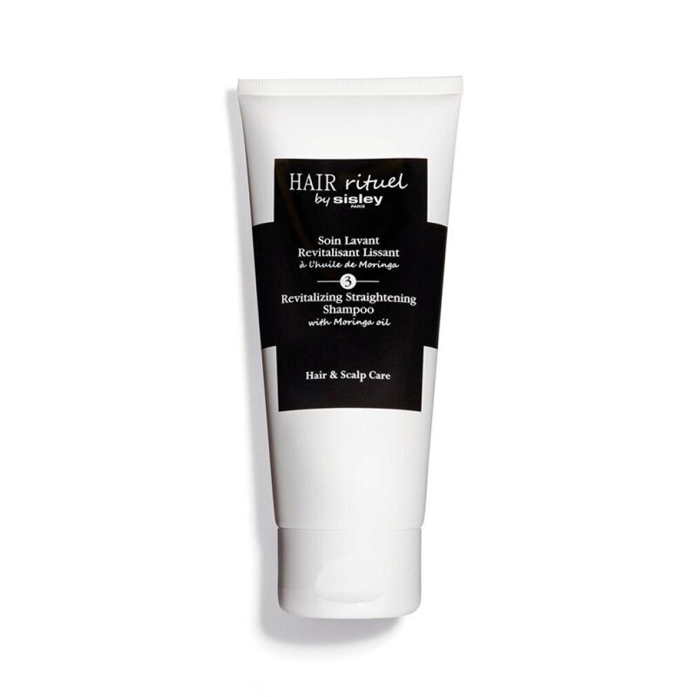 Weißer Tube mit schwarzem Etikett. Aufschrift: Hair Rituel by Sisley, Revitalizing Straightening Shampoo. Produkt für Haar und Kopfhaut.