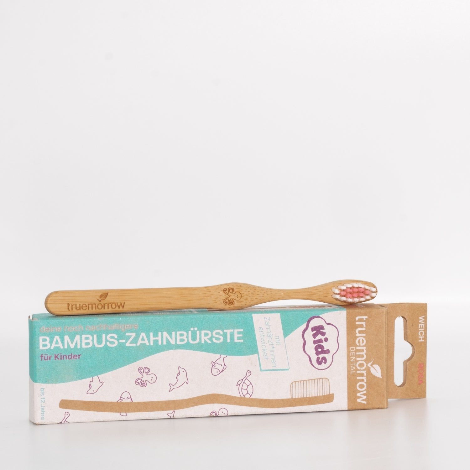 Zahnbürste aus Bambus mit Verpackung. Aufschrift: Bambus-Zahnbürste für Kinder. Marke: truemorrow. Rosa Borsten, weich.