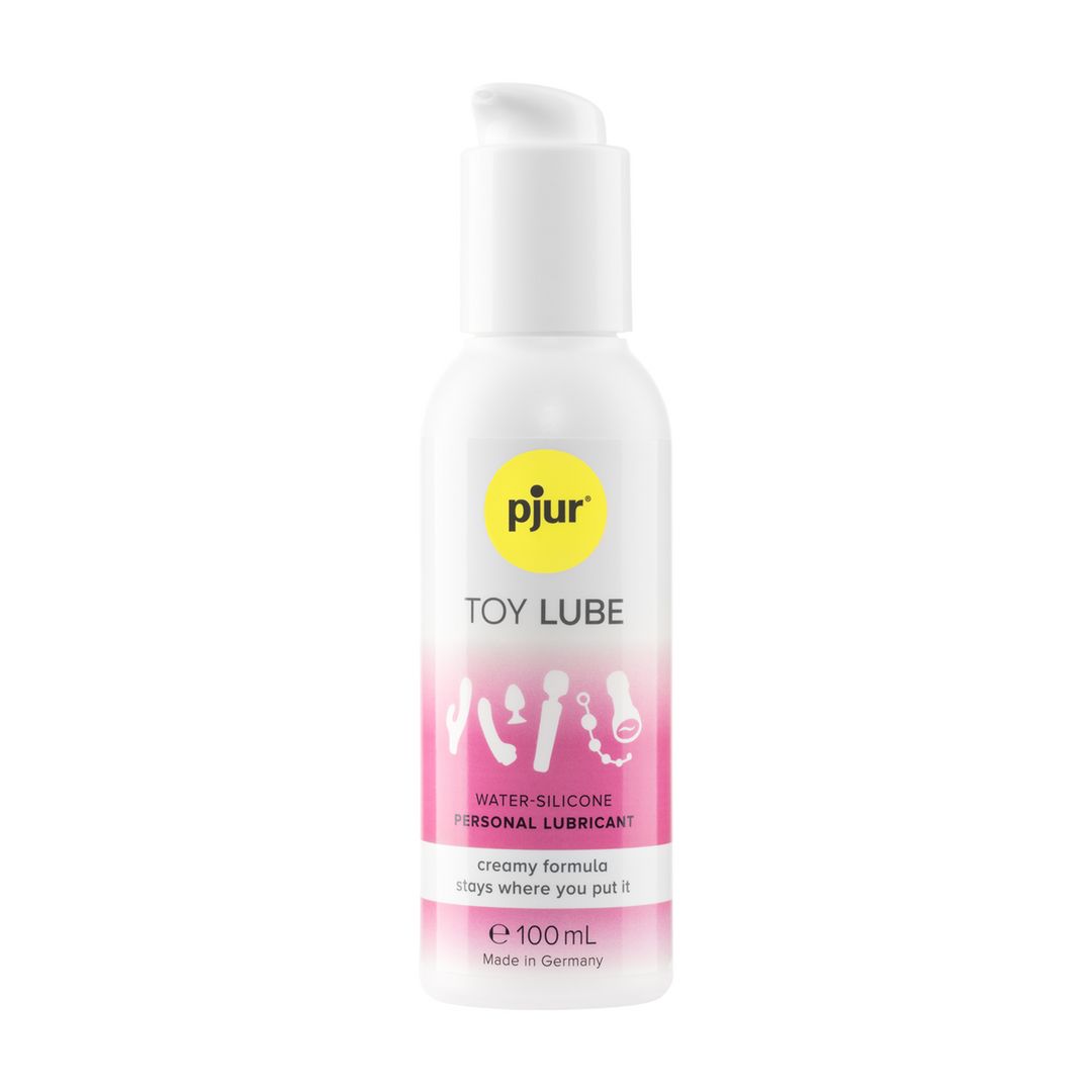 Weiße Flasche mit Pumpverschluss. pjur Toy Lube, rosa-weißes Etikett mit Symbolen. Wasser-Silikon-Formel. 100 ml. Hergestellt in Deutschland.