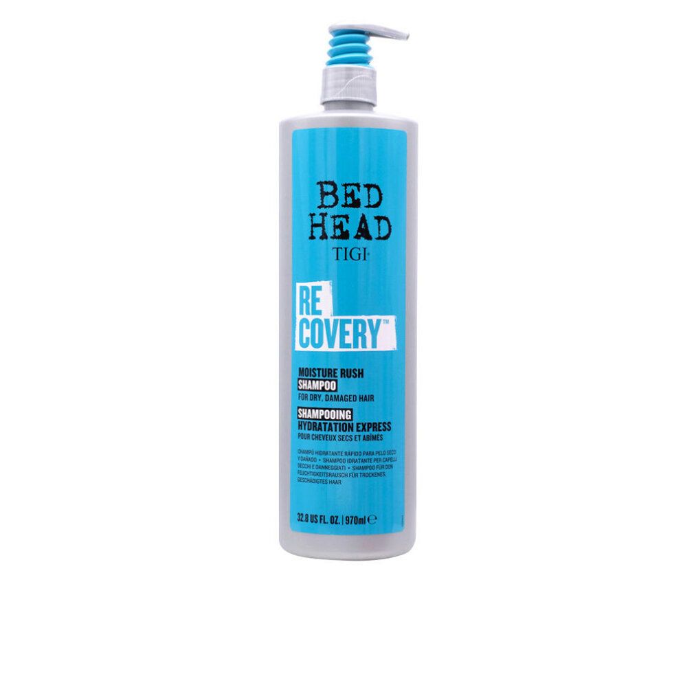 Graue Flasche mit blauem Etikett. Bed Head TIGI Re-COVERY Shampoo. Pumpkopf. Text: Moisture Rush Shampoo, für trockenes, strapaziertes Haar.