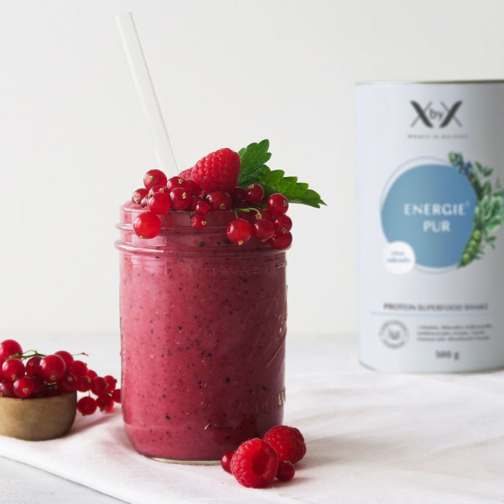 Glas mit Smoothie, Beeren und Dose. Dose mit Aufschrift: Energie Pur, Protein Superfood Shake. Smoothie mit Strohhalm.