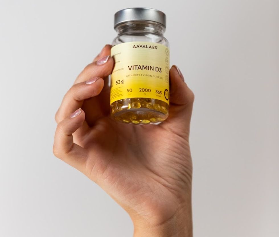 Hand hält eine Flasche Aavalabs Vitamin D3 mit 2000 IE, 365 Softgels.
