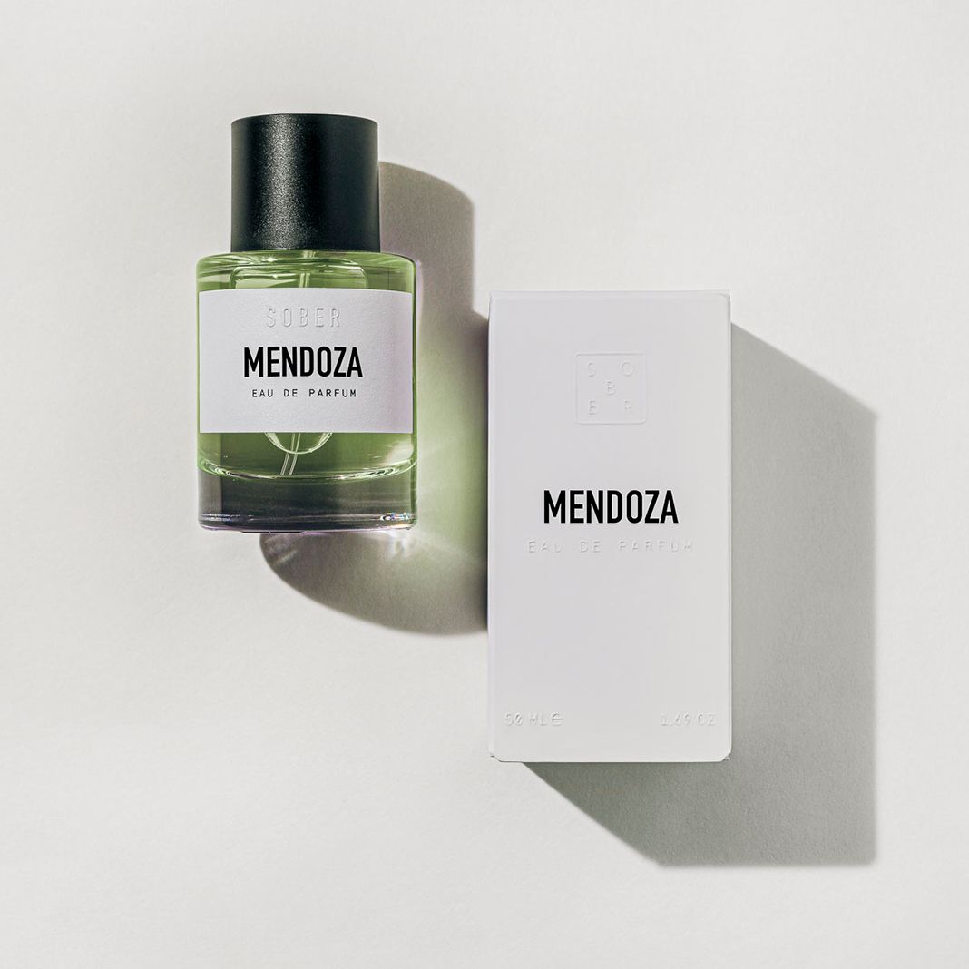 Parfümflakon und Verpackung. Aufschrift: SOBER, MENDOZA, Eau de Parfum. Flakon mit schwarzem Deckel, weiße Verpackung.