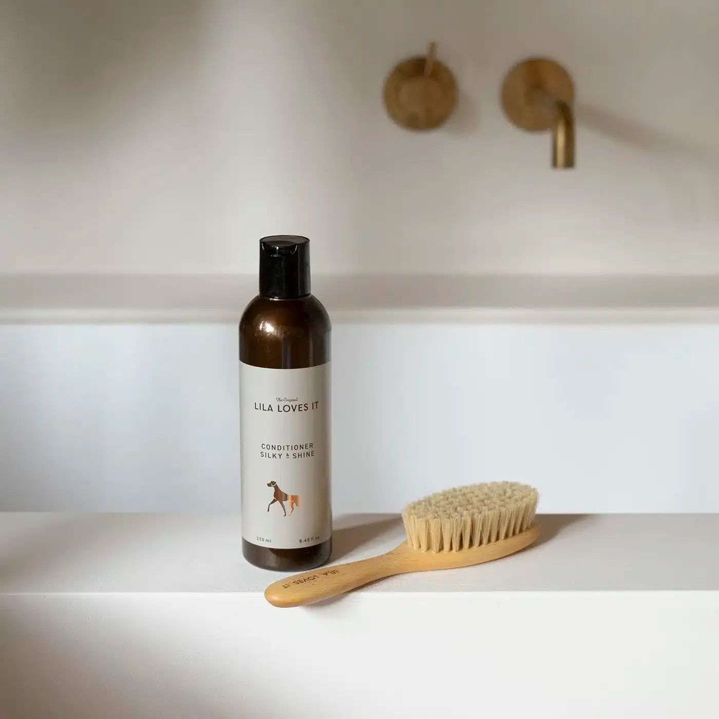 Flasche mit Etikett: LILA LOVES IT, Conditioner Silky & Shine. Neben Bürste mit Holzgriff und Borsten.