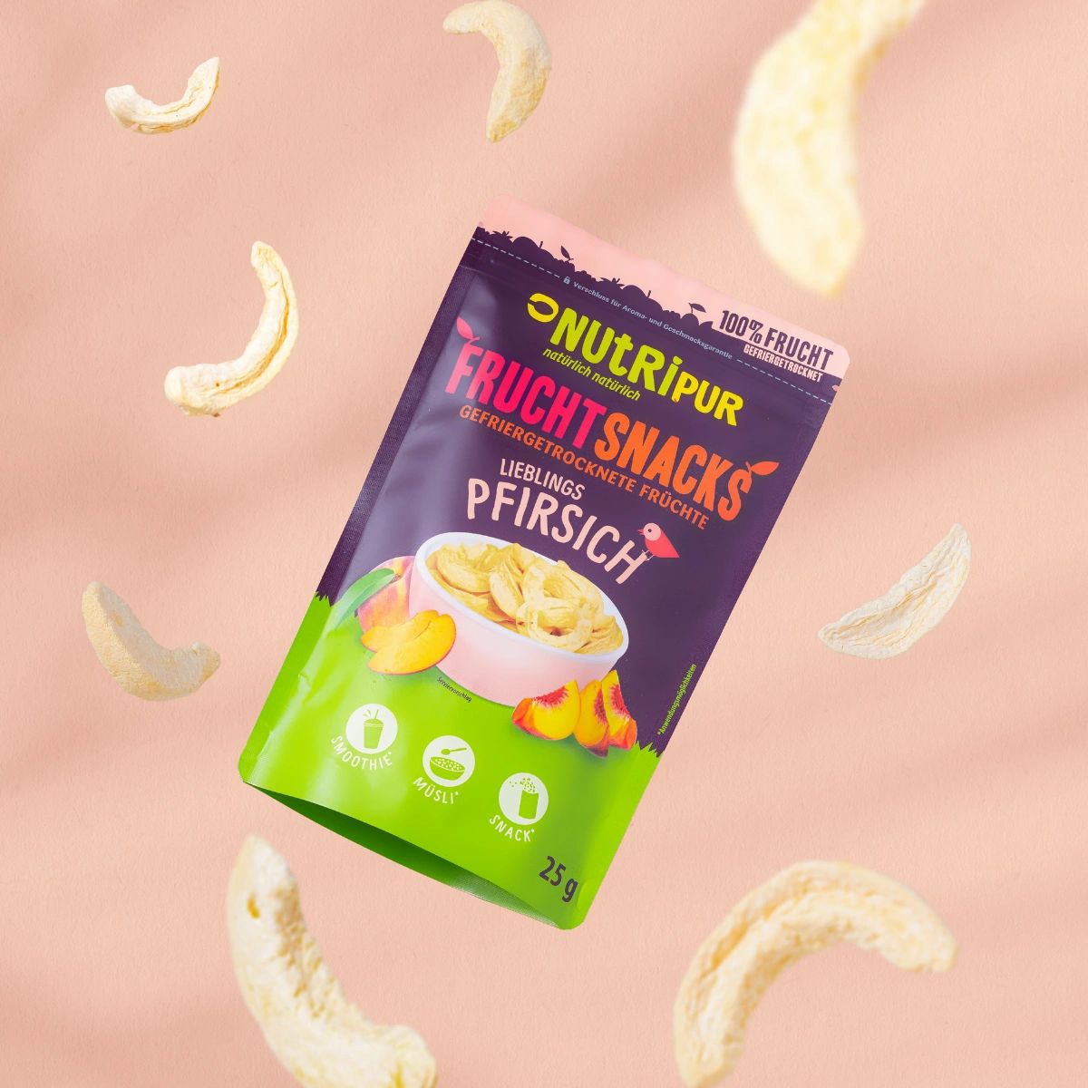 Verpackung mit gefriergetrockneten Pfirsich-Fruchtsnacks, umgeben von getrockneten Pfirsich-Scheiben. Auf rosa Untergrund.