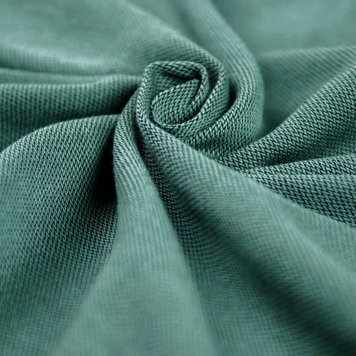 Grünes, gewebtes Material, gerollt. Detailaufnahme der Textur. Sichtbare Webstruktur.