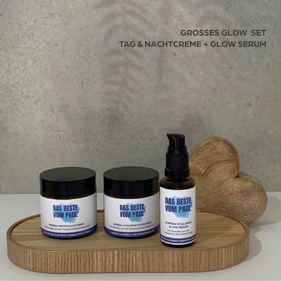 Drei Produkte auf einem Tablett. Aufschrift: Das Beste vom Paul. Großes Glow Set. Tages- und Nachtcreme, Serum. Holzherz als Dekoration.