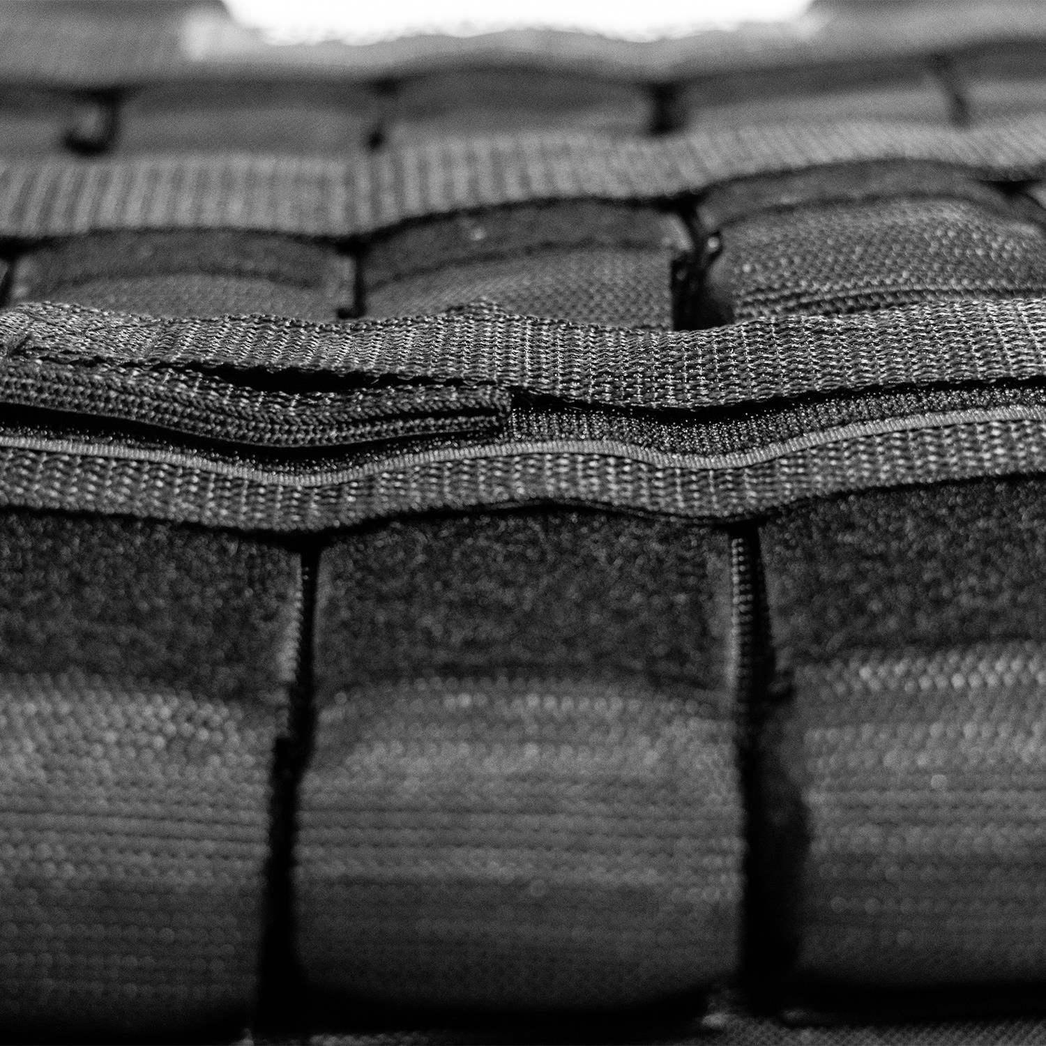 Nahaufnahme der Taschen und Gurte der schwarzen Gewichtsweste. Klettverschlüsse.