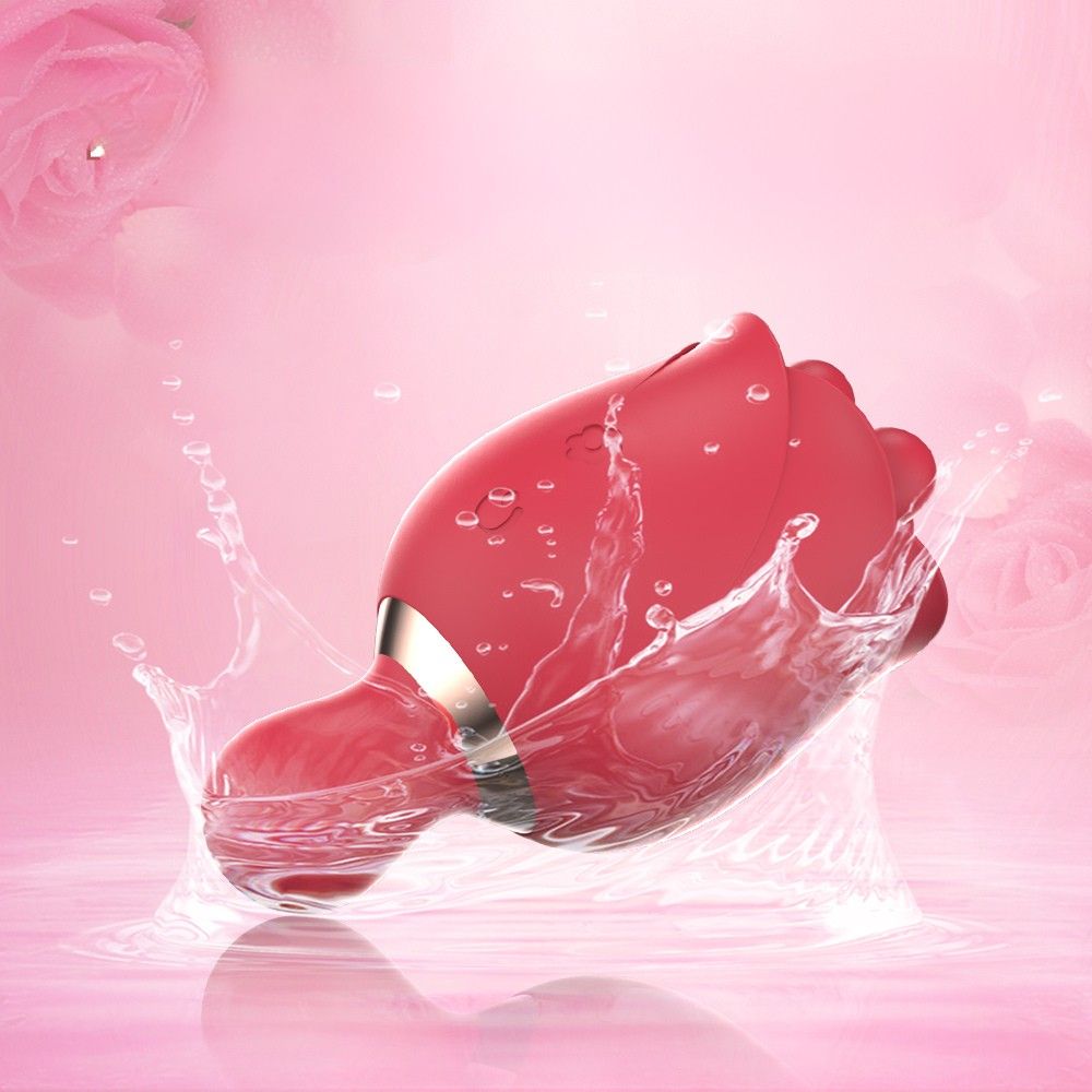 Roter Mini-Vibrator mit Wasserspritzern. Auf rosa Hintergrund.