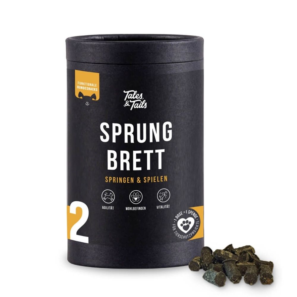 Schwarze Dose mit Aufschrift "Tales & Tails Sprungbrett". Daneben Hundesnacks. Auf der Dose: Logos und Text.