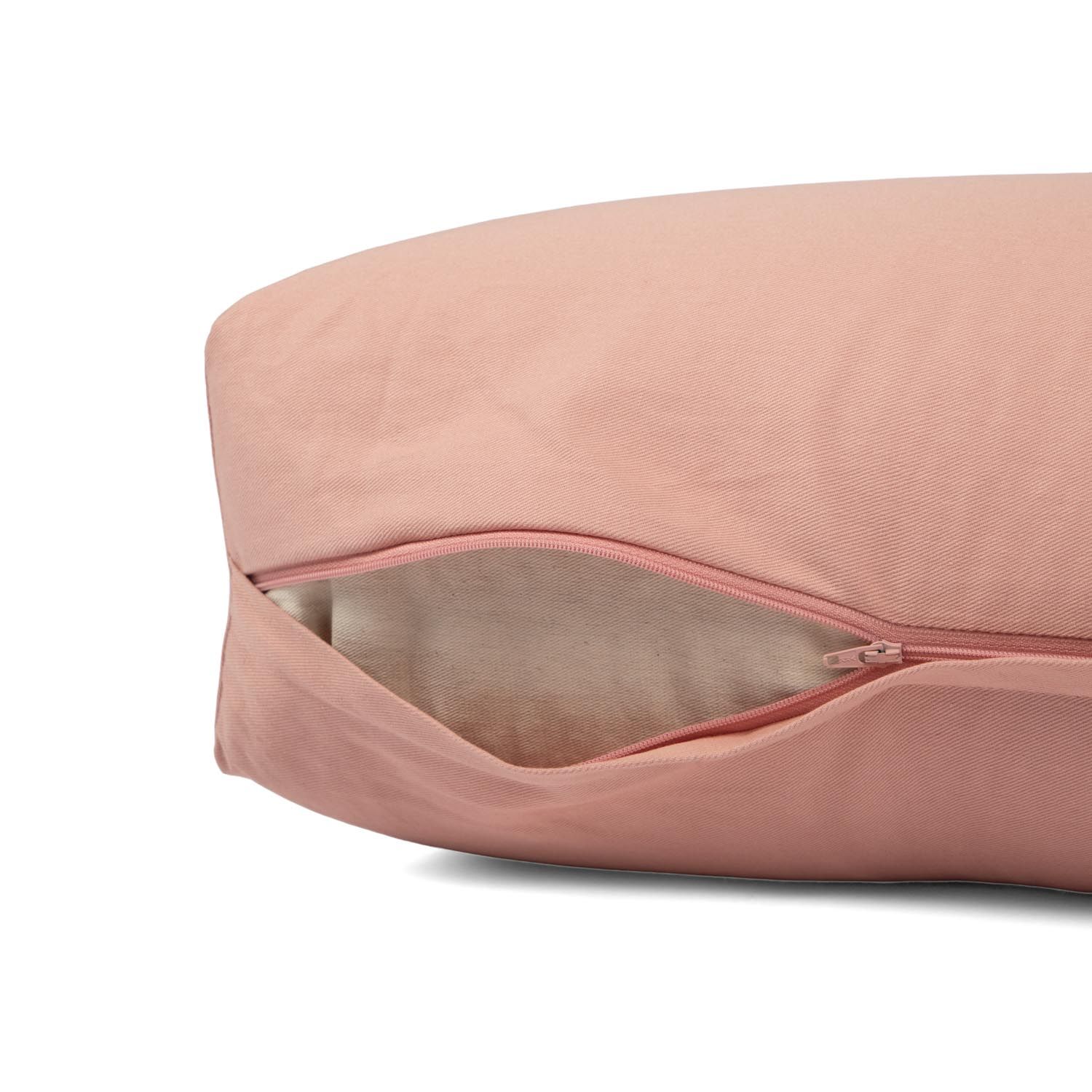 Nahaufnahme des Reißverschlusses an der Seite eines rosa Yoga-Bolsters, der den Blick auf die Füllung freigibt.