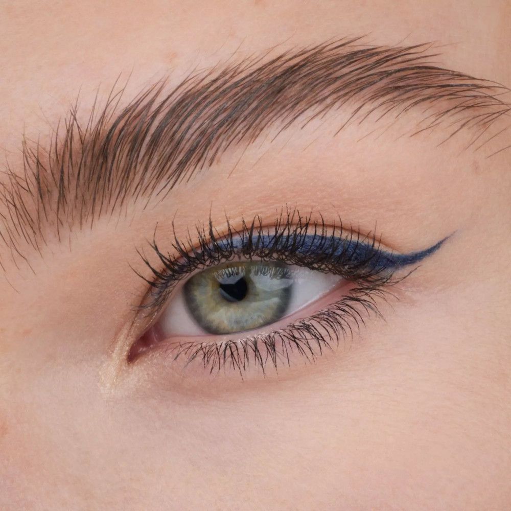 Nahaufnahme eines Auges mit blauem Eyeliner. Der Eyeliner ist präzise aufgetragen.