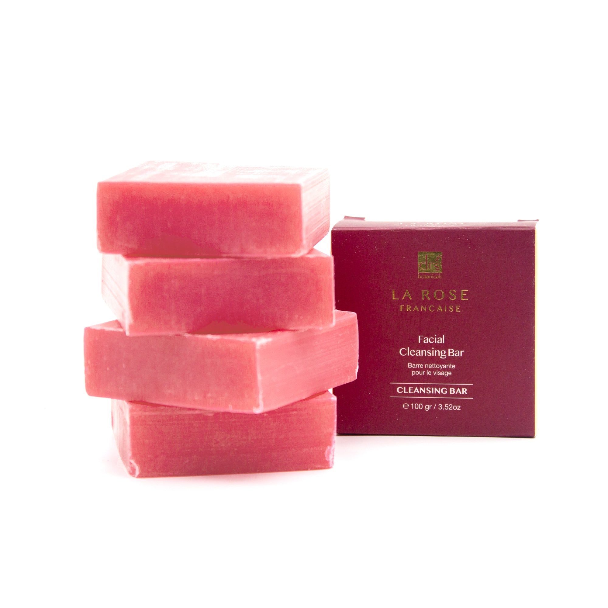 Fünf rosa Blockseifen gestapelt. Verpackung mit Logo und Text. "Facial Cleansing Bar".