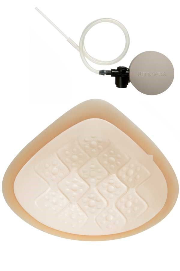 Hautfarbene Brustprothese mit strukturiertem Innenbereich und Pumpe mit Schlauch.