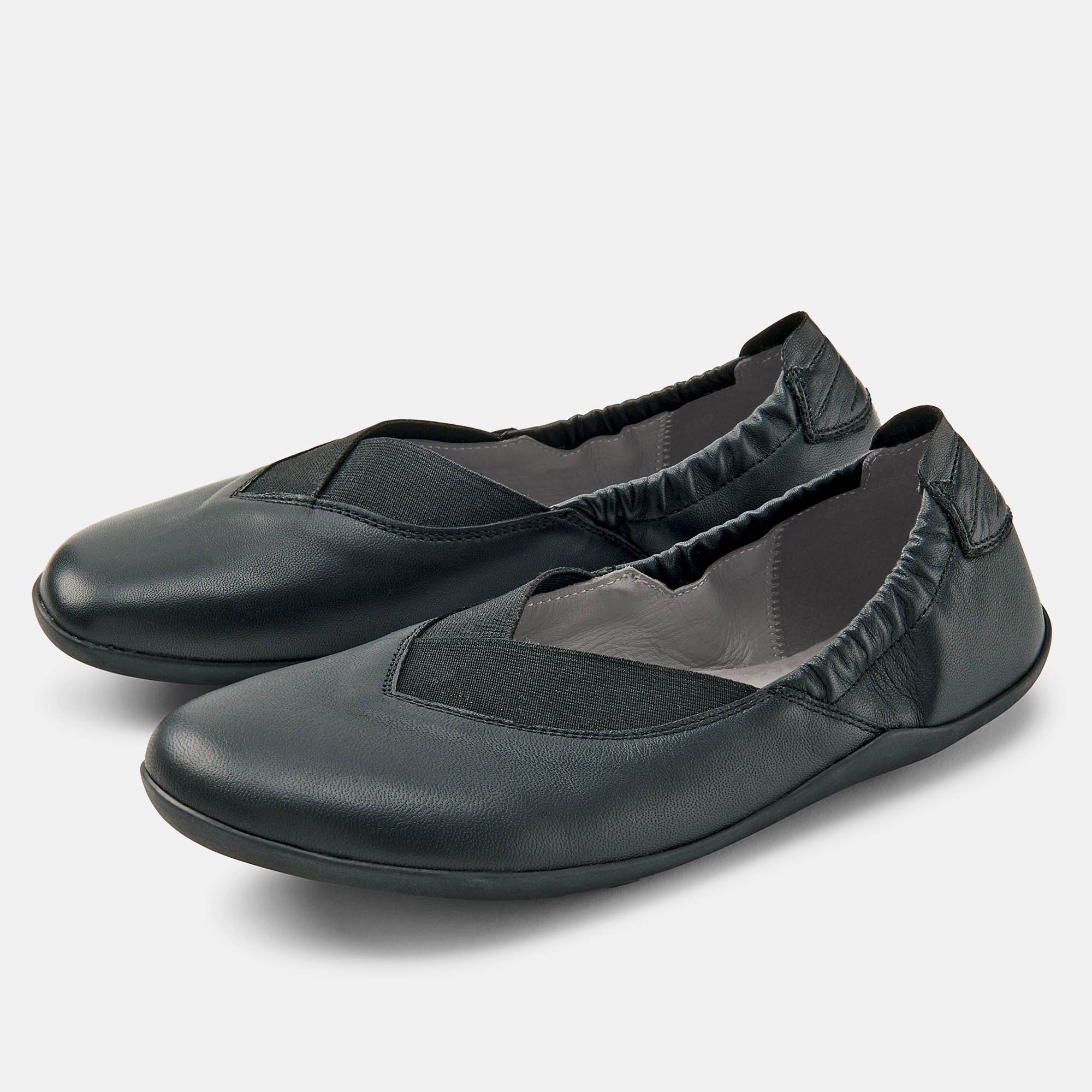 Schwarze Ballerina. Leder, elastischer Einsatz. Weite Form. Einzelner Schuh, leicht schräg gestellt.