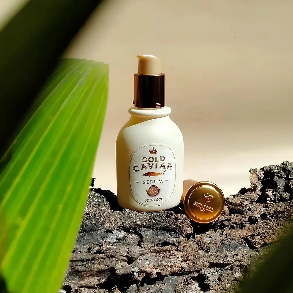 Gold Caviar Serum Flasche mit goldenem Verschluss. Text: Gold Caviar Serum, SKINFOOD.