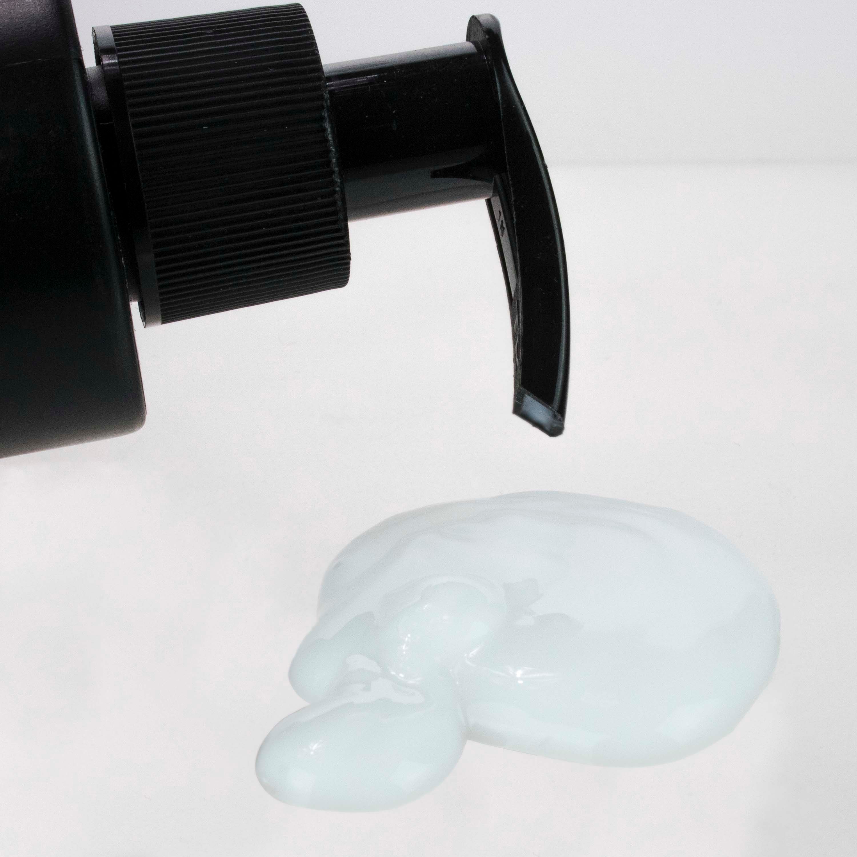 Nahaufnahme einer schwarzen Pumpflasche. Daneben eine helle, gelartige Substanz. Der Hintergrund ist weiß.
